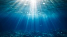 Deep sea water abyss with blue sun light.