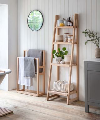 wooden bathroom storage shelves on a panelled wall