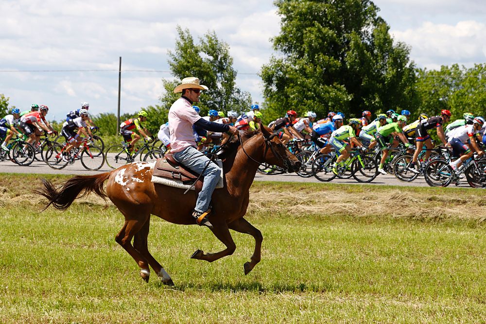 Giro d'Italia stage 13 - A man horseback riding alongside the peloton