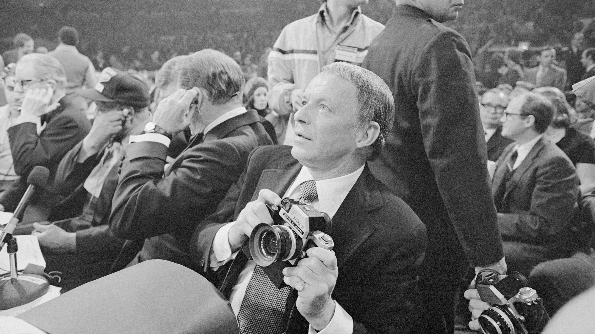 Singer-actor Frank Sinatra turns cameraman for the Frazier-Ali fight, March 8, and national magazine (life) featured his photos in their next issue. Singer-actor-photographer Sinatra has announced his planned retirement from Show Biz, but now that he&#039;s achieved success in three fields, why not four? He says he&#039;ll probably try his hand at writing.