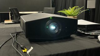 Sony Bravia Projector 9 on a black tablecloth with a PS5 on the right hand side