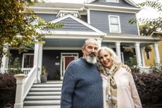 Older couple in front of their home.
