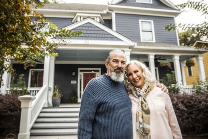 Older couple in front of their home.