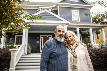 Older couple in front of their home.