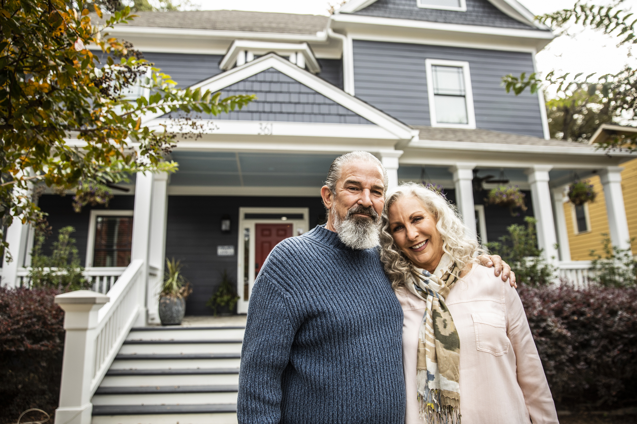 Older couple in front of their home.