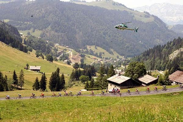 A helicopter shadows the riders