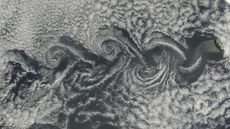 Satellite image of cloud vortices swirling behind islands in the Atlantic Ocean