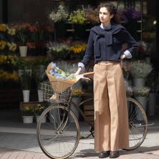 Woman wearing Uniqlo clothing next to a bike with a basket of flowers