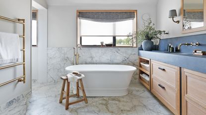 view into a neutral en suite bathroom and bath via a sliding glass door
