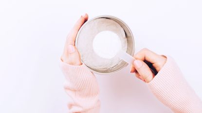 woman scooping collagen powder