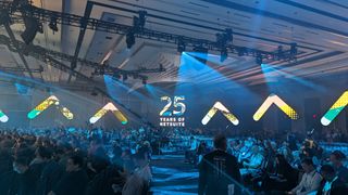 A crowd seated in the main ballroom for SuiteWorld 2023, with a large screen displaying the words '25 years of NetSuite'.