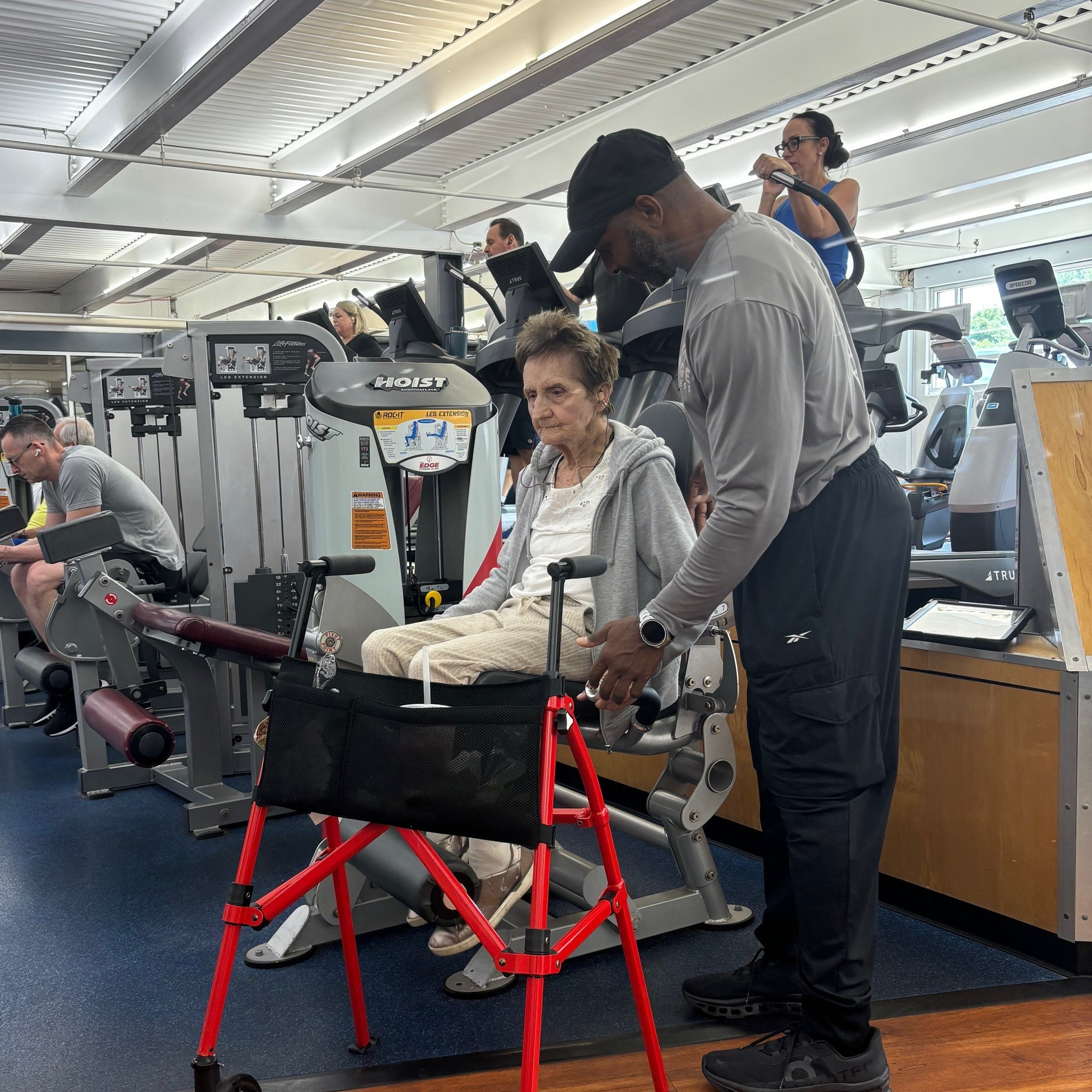 100-year-old Mary Coroneos sits in a hip adductor machine at a gym