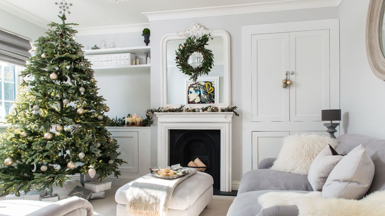 Decorated real Christmas tree inside furnished white and grey themed living room