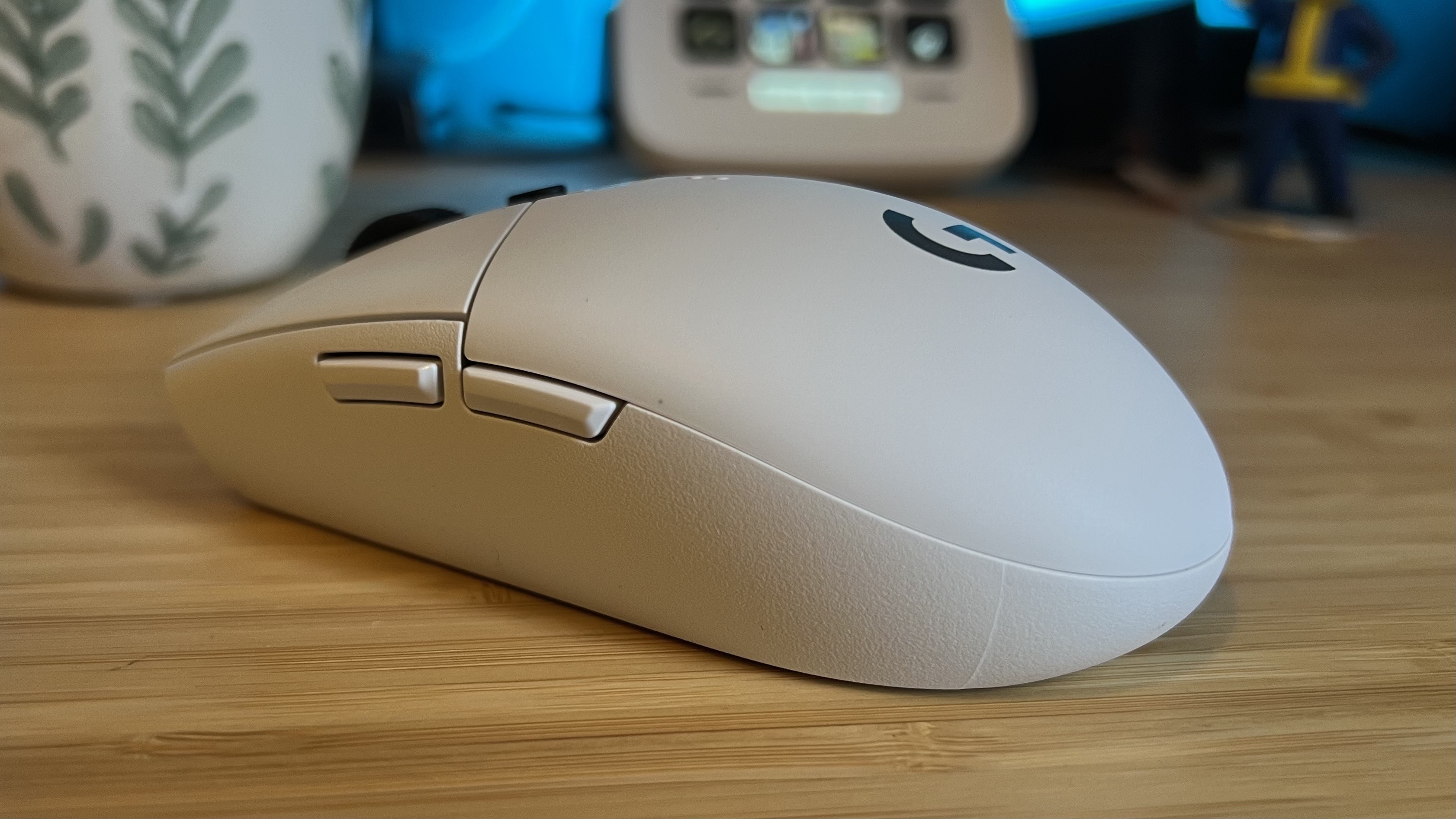 Right side of Logitech G305 Lightspeed gaming mouse with close up on side buttons on wooden desk