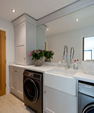 small laundry room with mirrored splashback