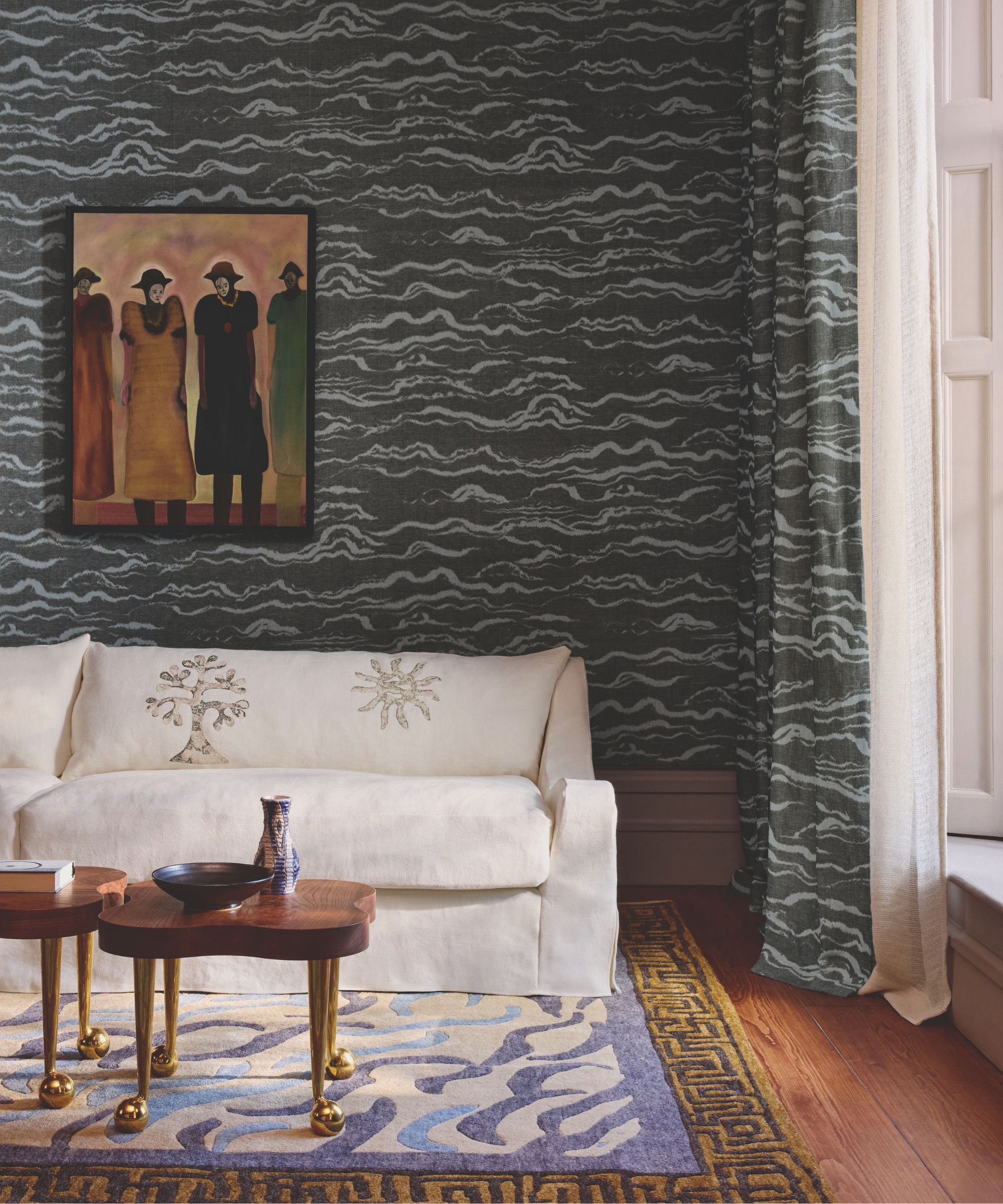 Sitting room with white sofa, patterned rug and a grey wall mural