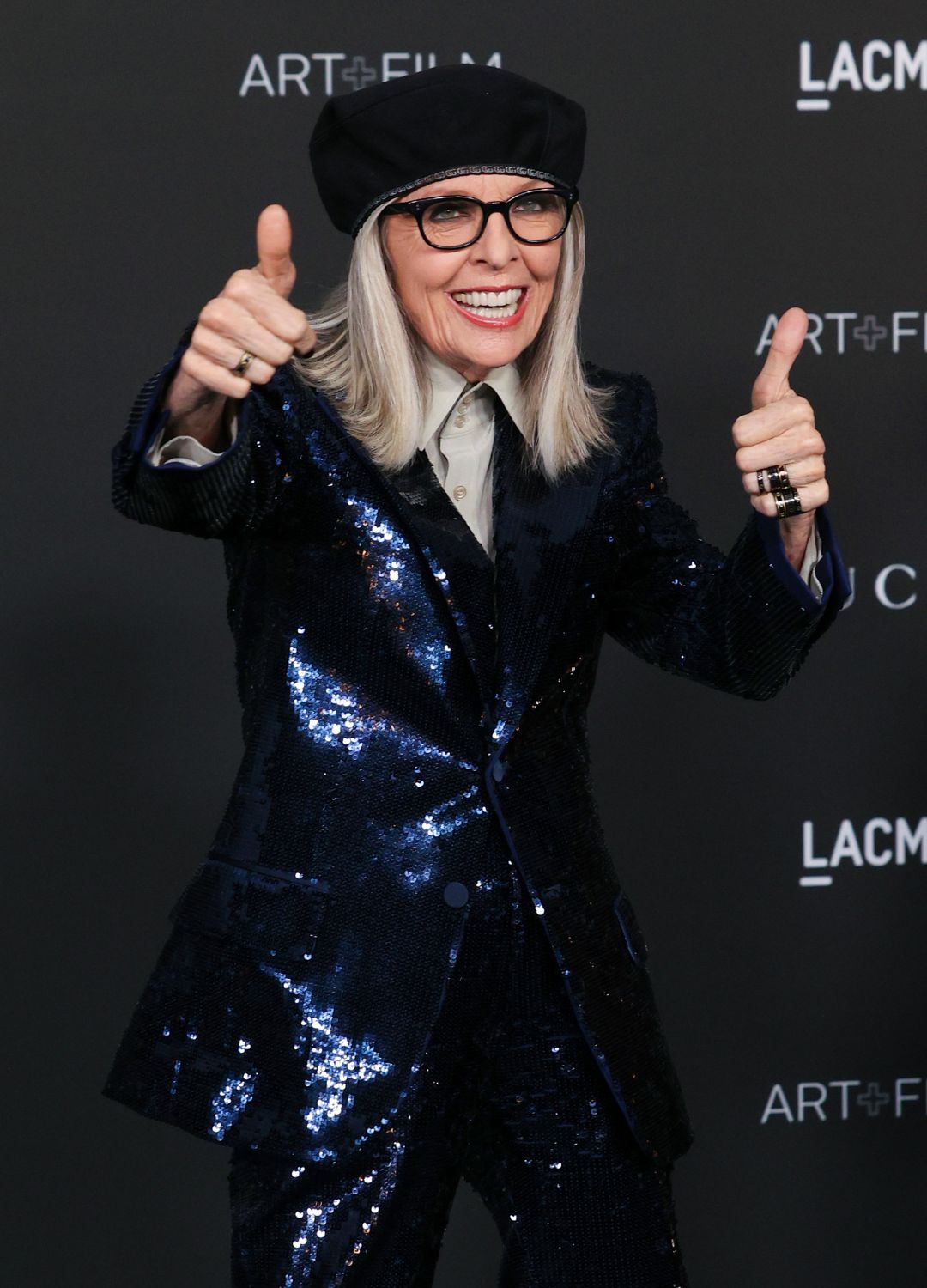 Diane Keaton in a sequin suit, sticking her thumbs up