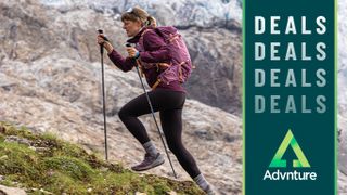 Woman speed hiking wearing Osprey backpack and carrying trekking poles