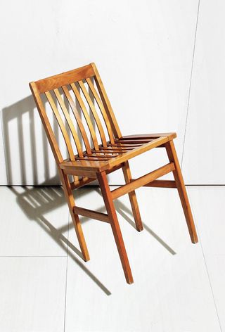 Image of a wooden chair tilted at angle to the left