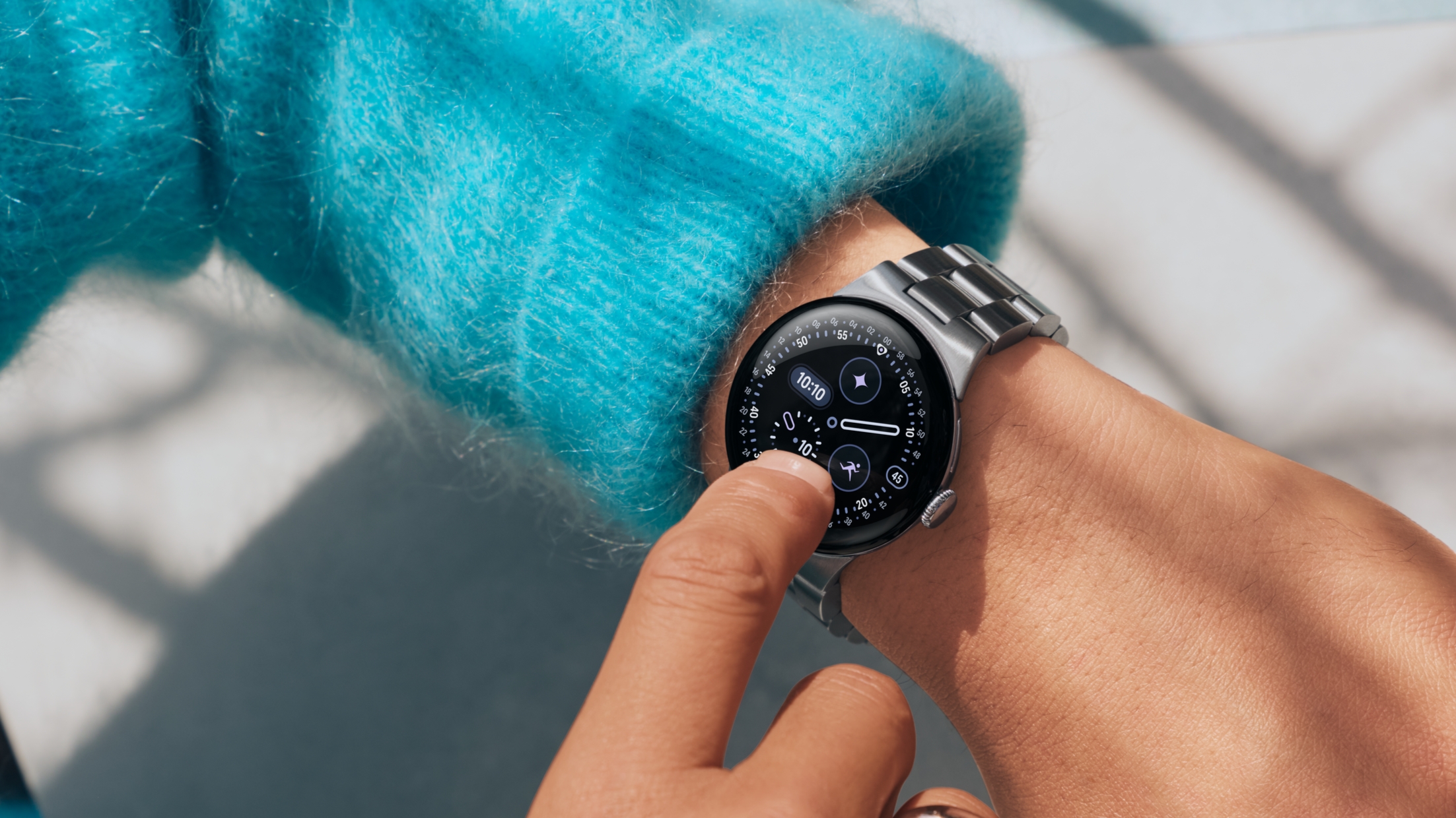 Pixel Watch 4 with its stainless steel metal watch band on a model's wrist.