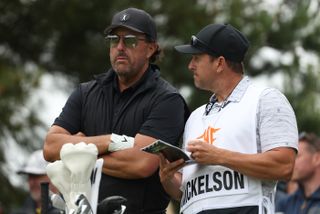 Phil Mickelson talks to his caddie whilst at the LIV Golf Invitational Series
