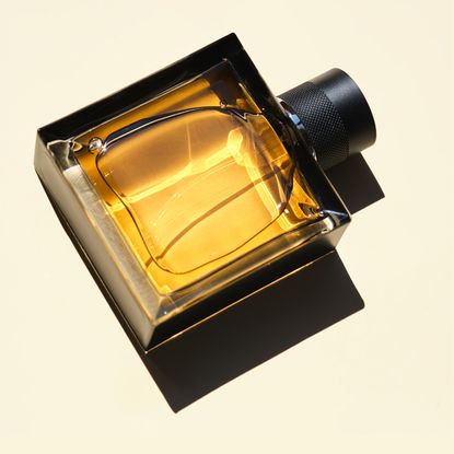 Close up of square golden perfume bottle 
