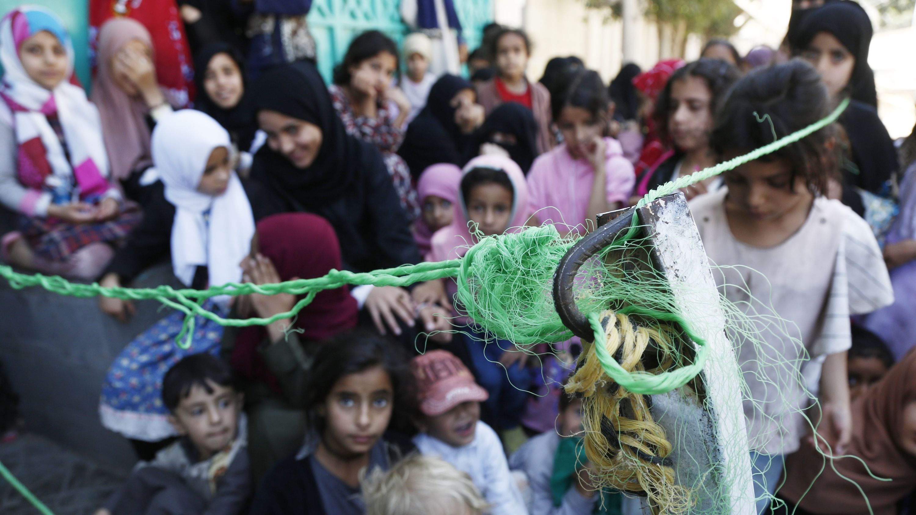 children waiting for food with a hook and net in front