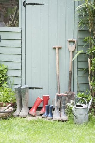 how to paint a shed: wellies and tools outside shed door