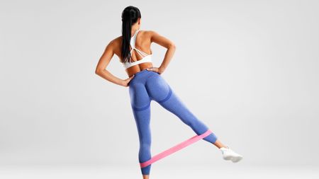 a photo of a woman doing a resistance band glute exercise 