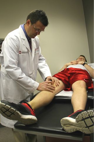 Dr. James Borchers examines the knee of a spring sport athlete at Ohio State's Wexner Medical Center. Borchers says athletes who play one sport that spans extremes in weather face unique injury risks. Sports like lacrosse often begin in frigid weather when frostbite and slick footing is a risk, but end in the warmth of late spring when dehydration and cramping are bigger threats.