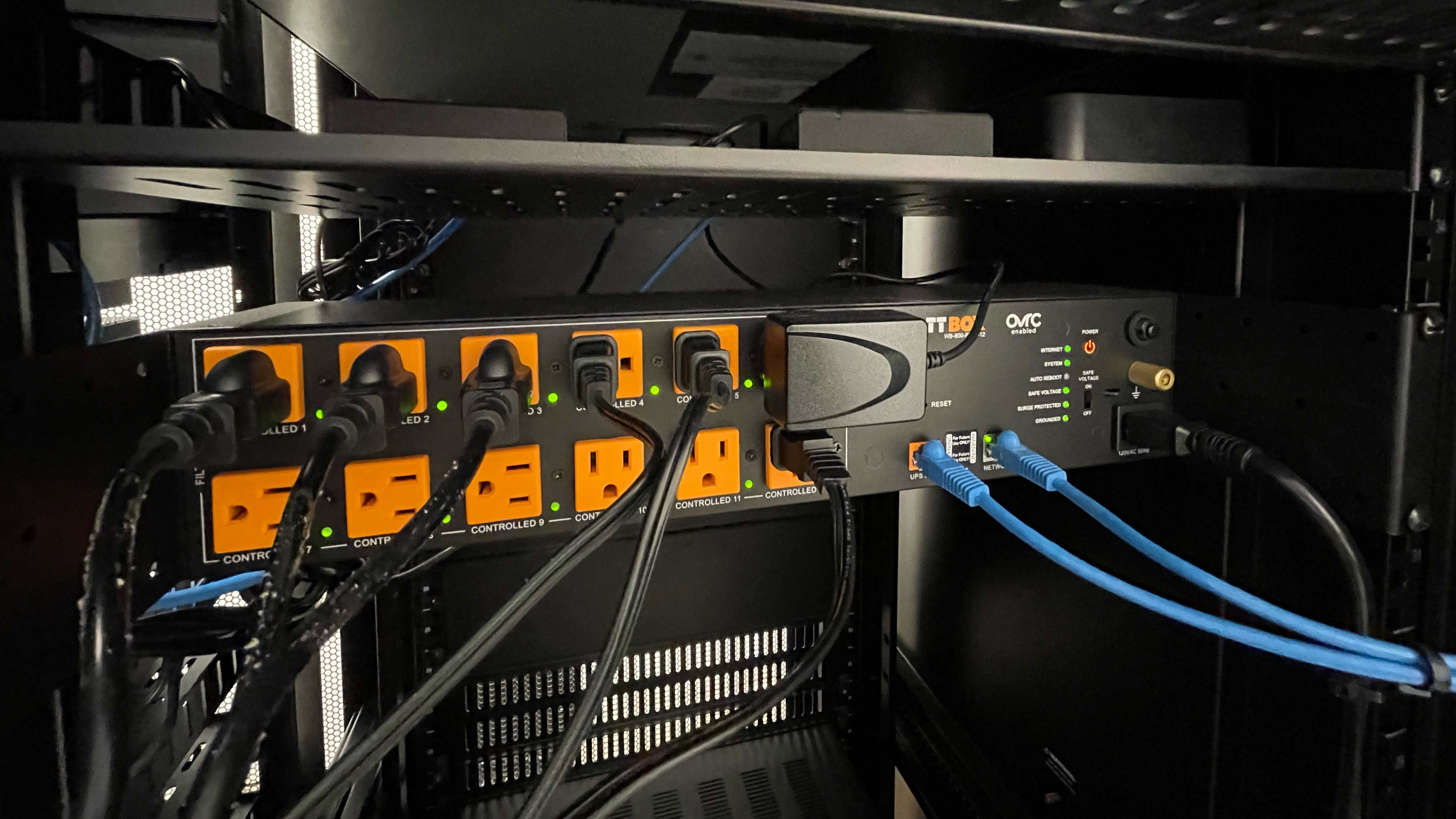 An orange circuit board in a cabinet with plugs running Snap One technologies. 