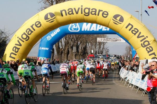 The peloton goes under the start-finish banner.