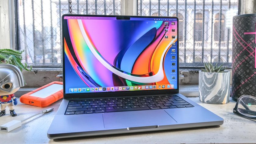 The MacBook Pro 2021 (14-inch) on an office table surrounded by accessories