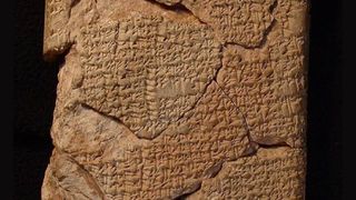 A close-up of a clay tablet with cuneiform writing