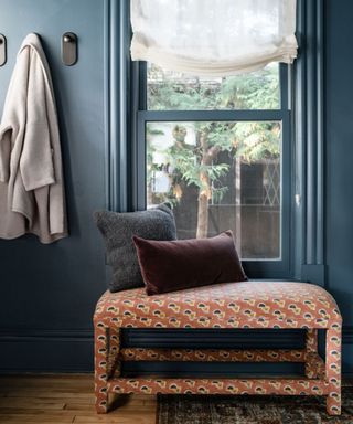blue entryway with upholstered bench and soft roman blinds