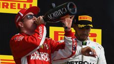 Kimi Raikkonen celebrates his win at the F1 United States GP while Mercedes driver Lewis Hamilton finished third