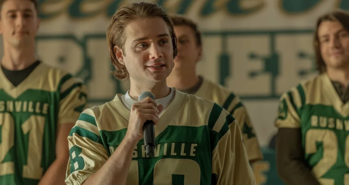 a blond-haired youth in a high school football jersey