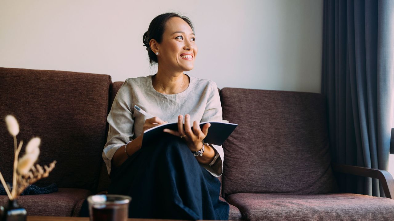 woman journaling on the sofa
