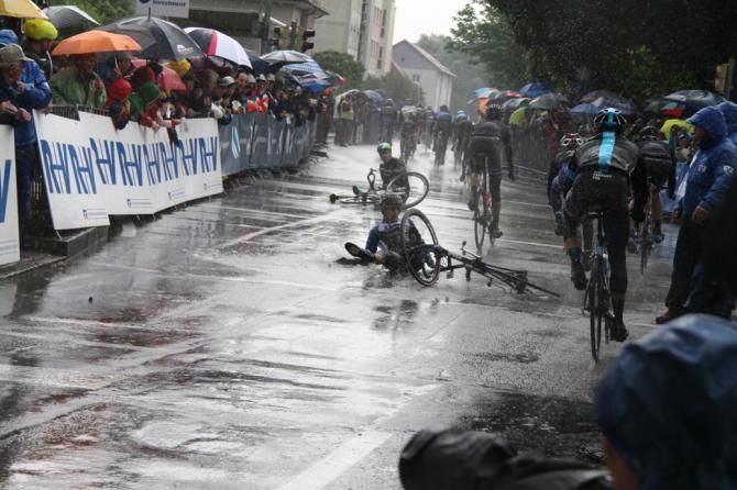 A riders crashes after the finish line due to the wet weather