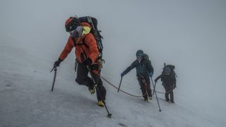 Three members of the expedition climbing up Mount Michael in poor visibility conditions.