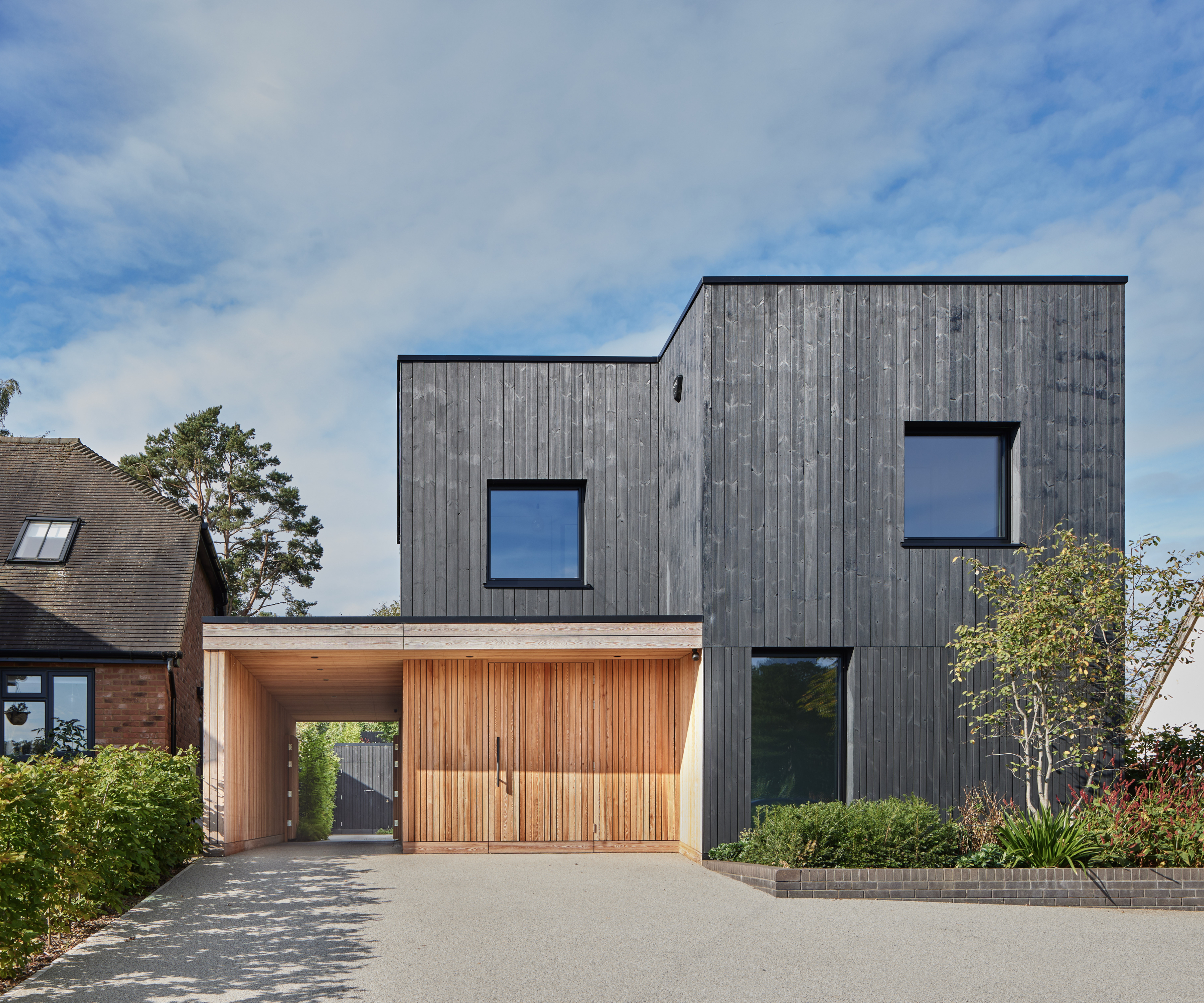modern grey timber clad self build with slightly sloping resin bound driveway