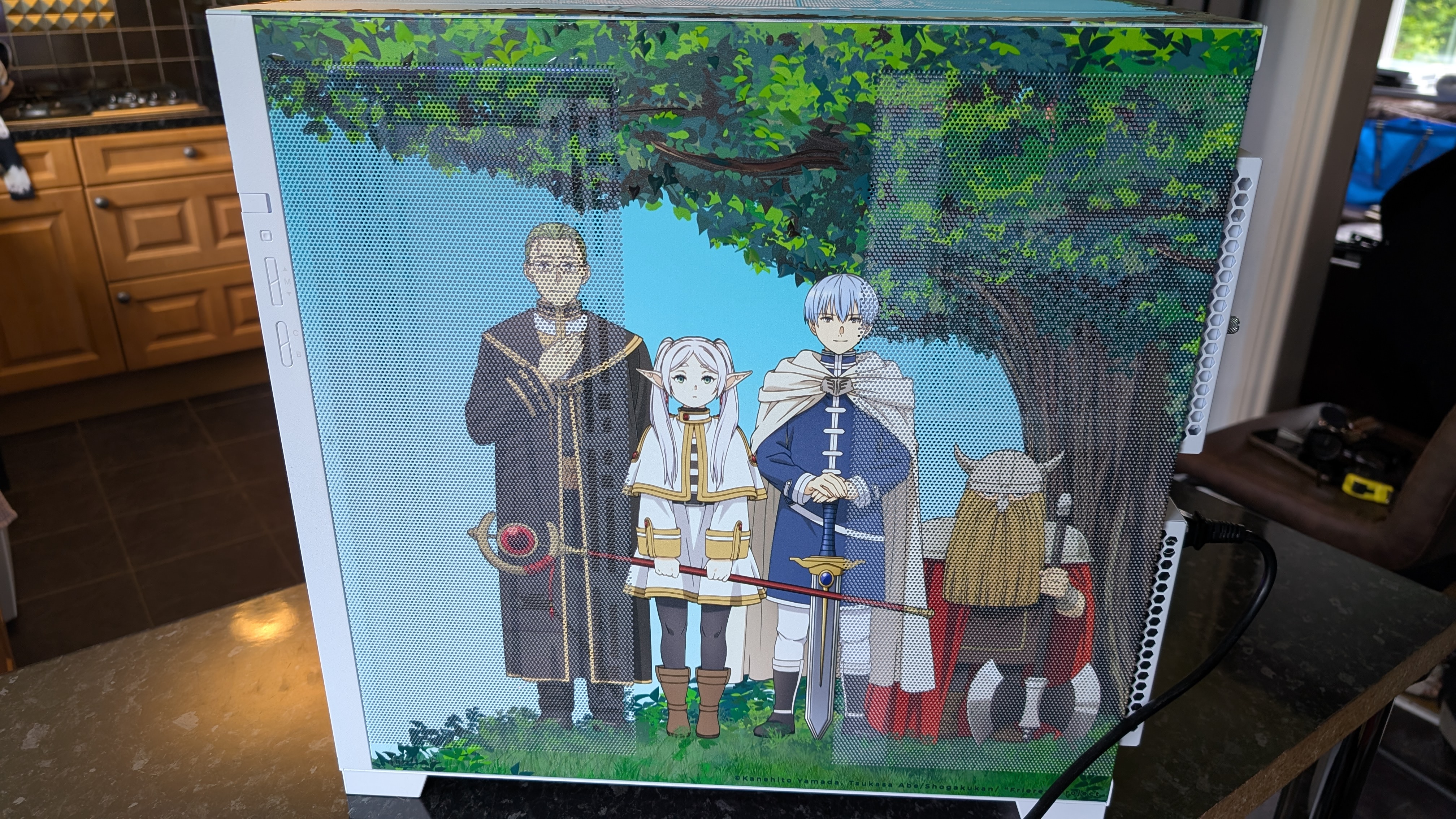 The Starforge Systems Frieren PC, photographed on a dark worktop with the RGB lighting switched on.