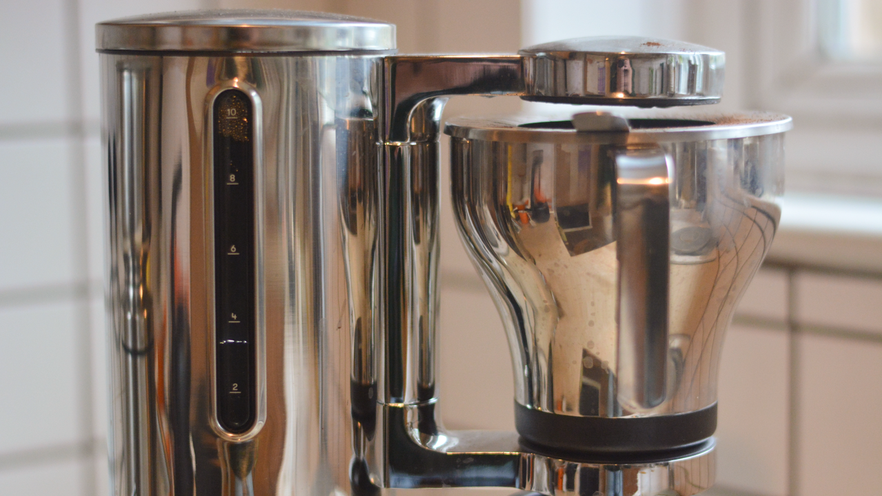 Image of the Aarke Coffee System &ndash; a stainless steel coffee bean grinder and drip coffee maker &ndash; positioned on a kitchen counter