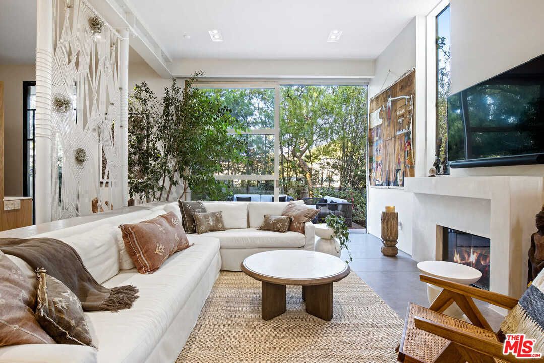 A living room with floor to ceiling windows that look out on a garden