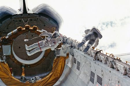 STS-6 crewmates Don Peterson (at right) and Story Musgrave perform the first shuttle-era spacewalk outside Challenger in 1983.