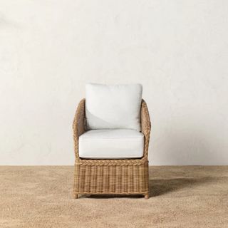 An outdoor wicker chair with cushion
