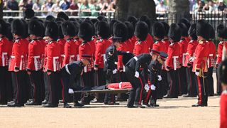 A Welsh Guardsman is stretchered away during the Colonel's Review
