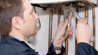 Plumber at Work on a Water Boiler
