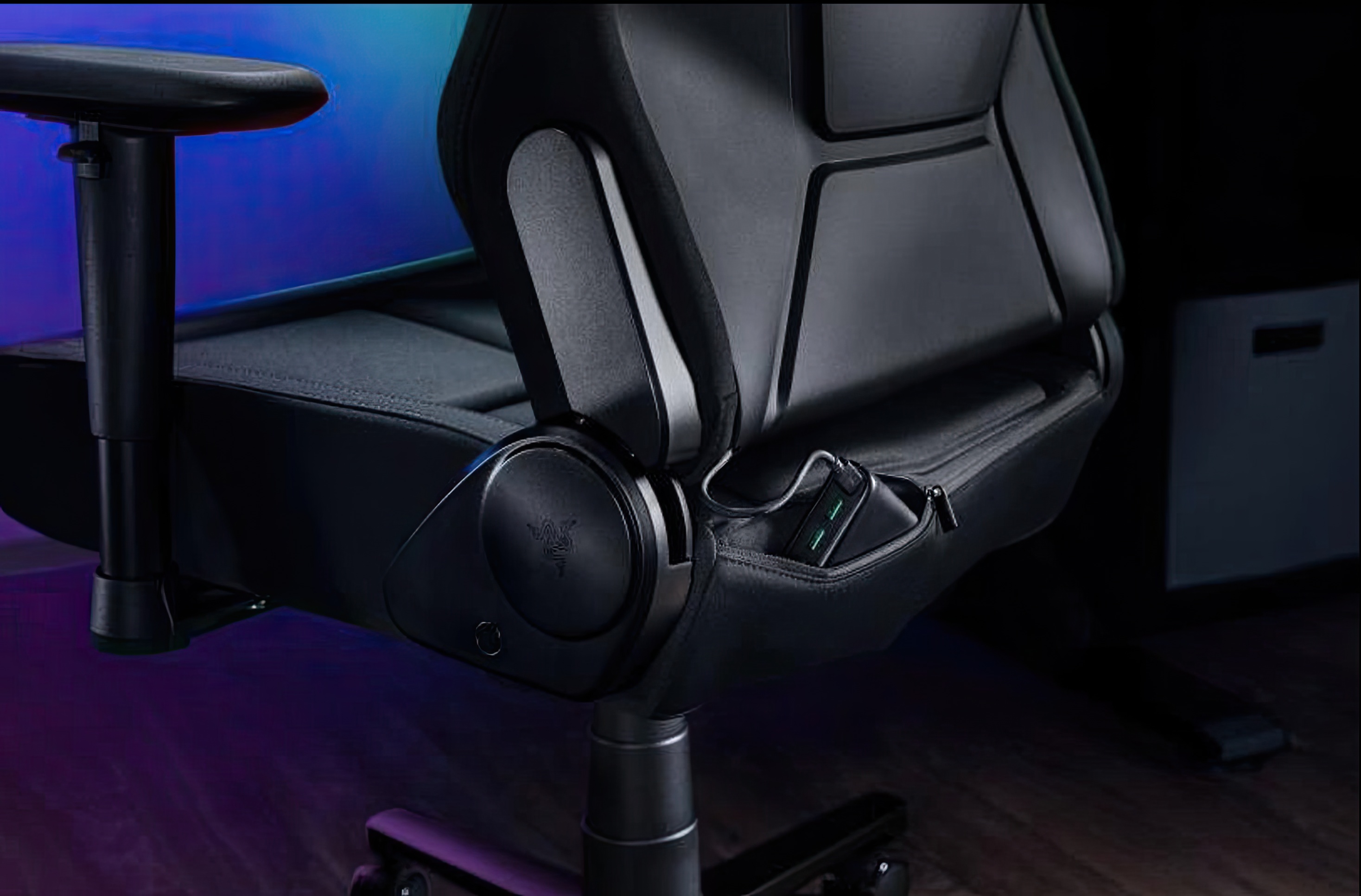 Press images of the Razer Chroma gaming chair, in black, with RGB lighting on the headrest