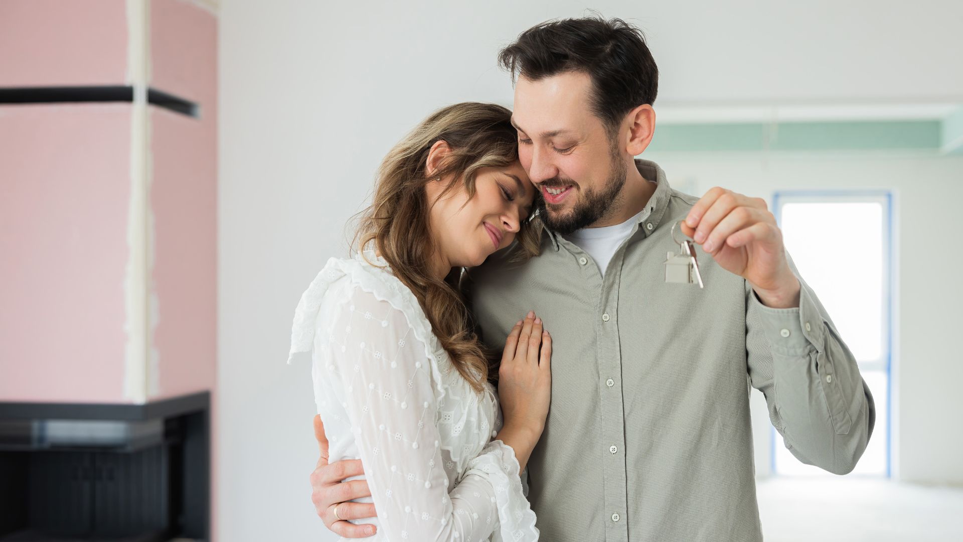 young couple holding keys in first home